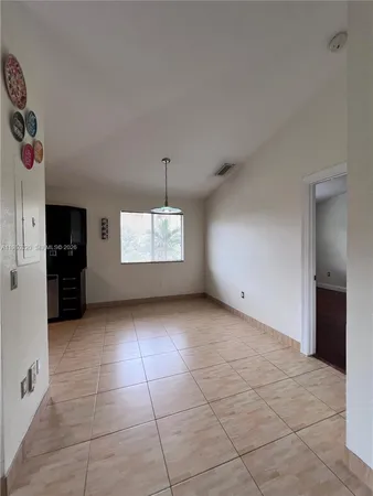 a view of an empty room with a kitchen