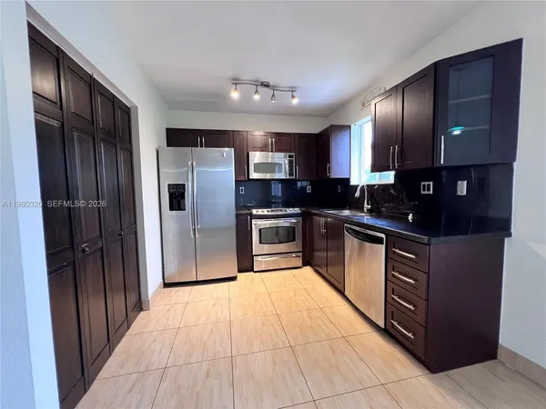 a kitchen with stainless steel appliances granite countertop a refrigerator and a sink