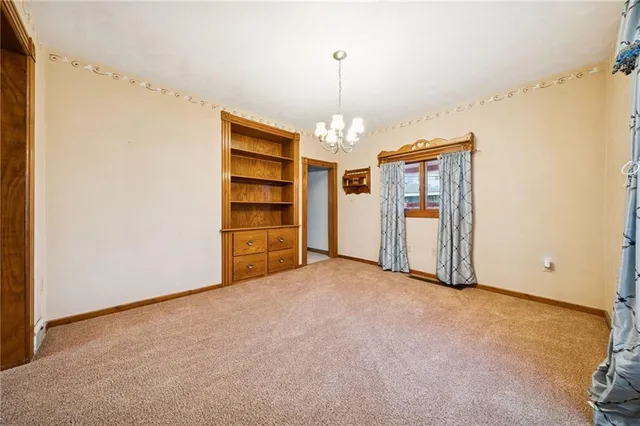 an empty room with closet and chandelier