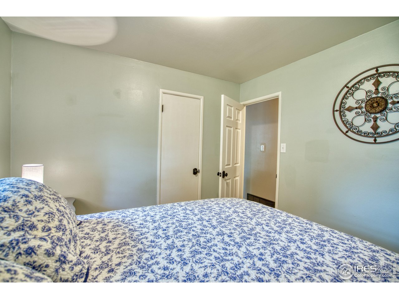 361 Delaware Street Sterling, CO 80751 - Photo 12 of 27 a bedroom with a bed and a painting on the wall
