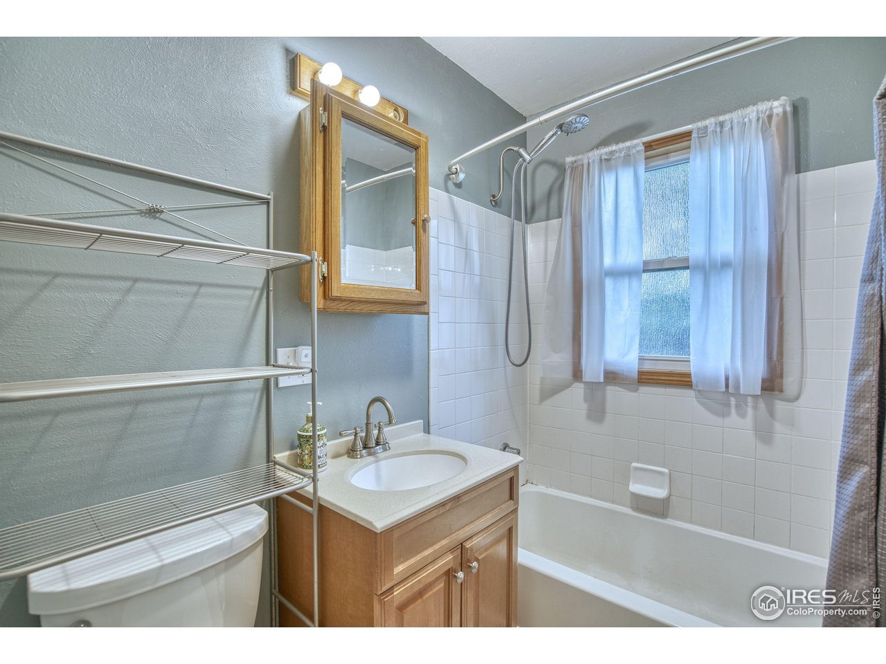 361 Delaware Street Sterling, CO 80751 - Photo 15 of 27 a bathroom with a sink a mirror and a bathtub