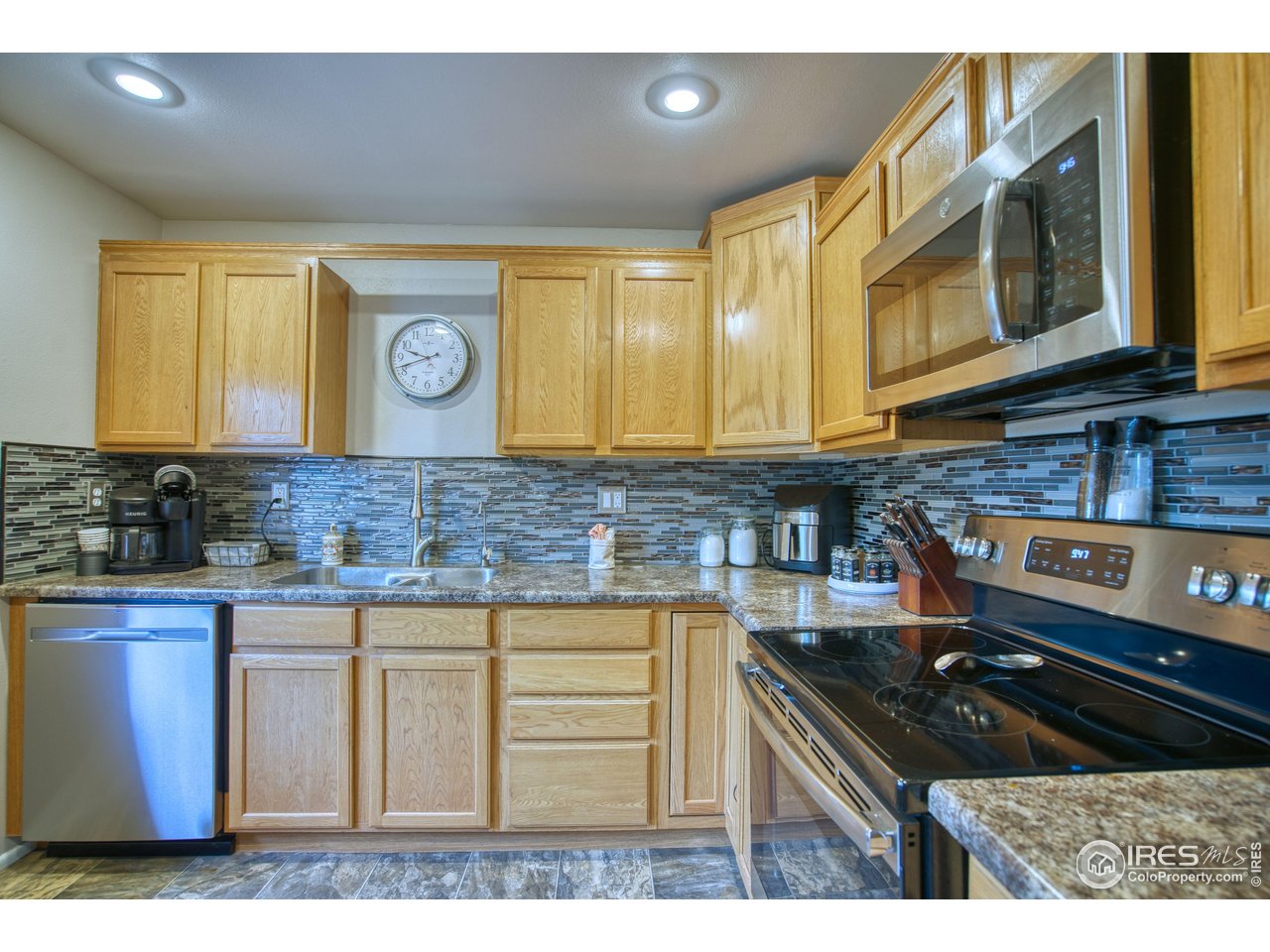 361 Delaware Street Sterling, CO 80751 - Photo 6 of 27 a kitchen with granite countertop a stove a sink and a microwave