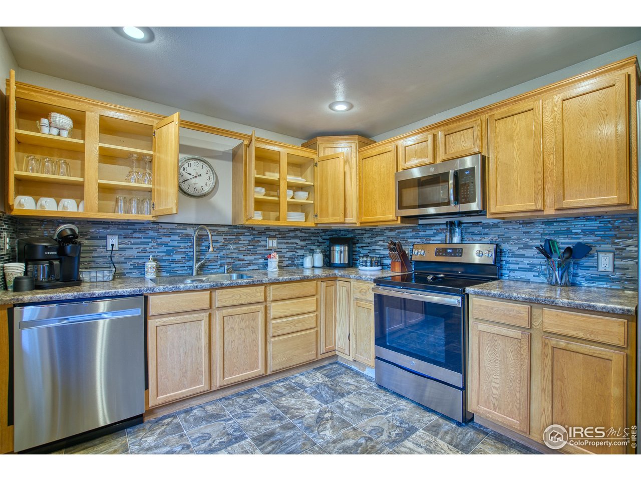 361 Delaware Street Sterling, CO 80751 - Photo 7 of 27 a kitchen with stainless steel appliances granite countertop a stove a sink and a microwave