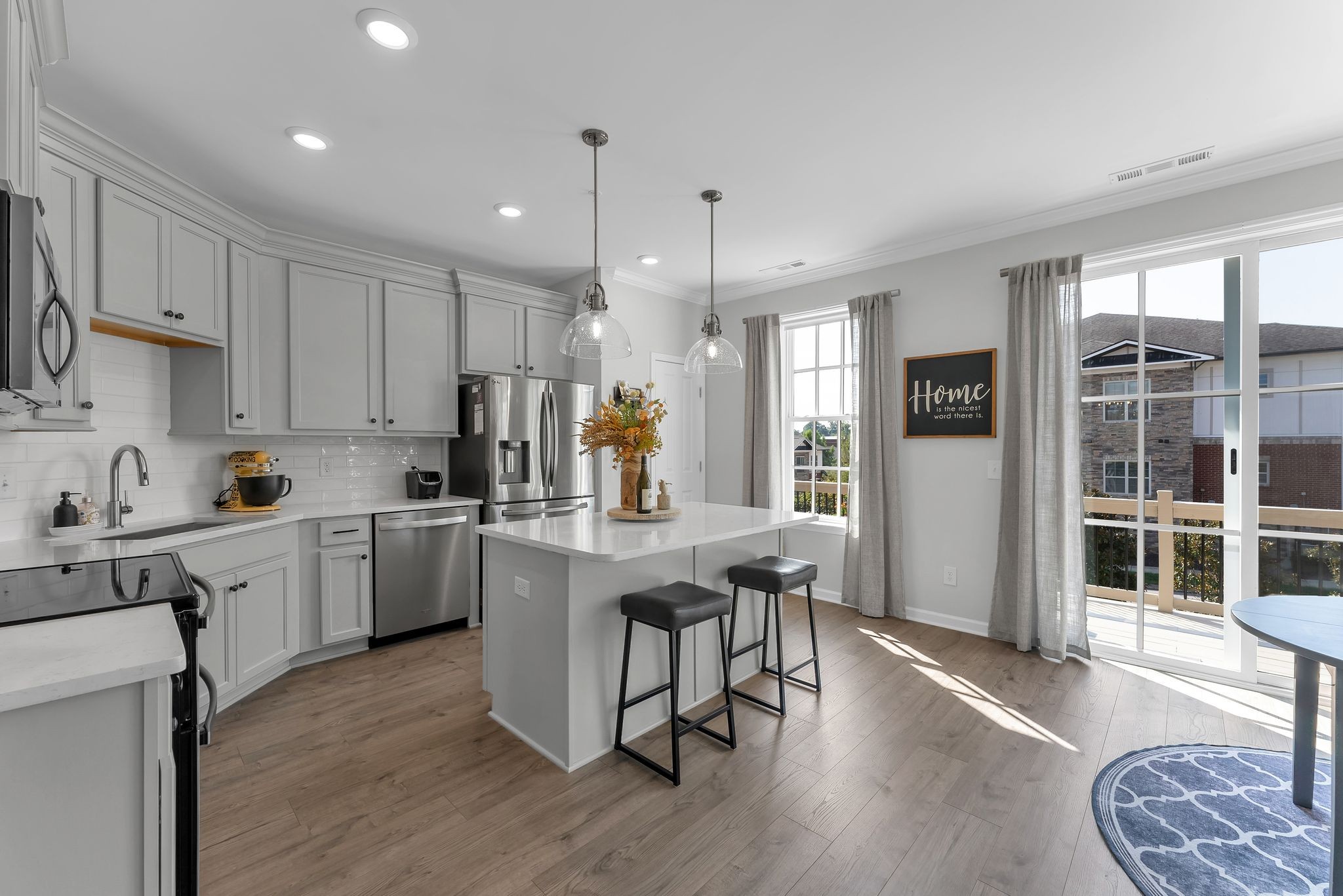 2083 Tollgate Boulevard Thompson's Station, TN 37179 - Photo 14 of 40 a kitchen with stainless steel appliances granite countertop a stove a sink a refrigerator and white cabinets with wooden floor