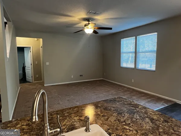 a view of a livingroom with a piano and wooden floor