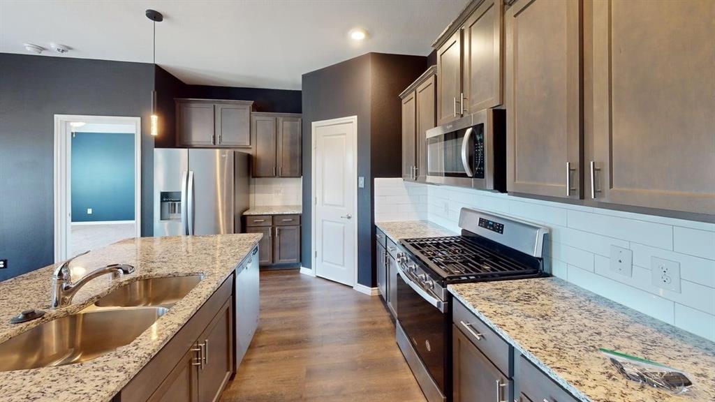 405 Rawhide Way Princeton, TX 75407 - Photo 3 of 22 a kitchen with stainless steel appliances granite countertop a sink stove and refrigerator