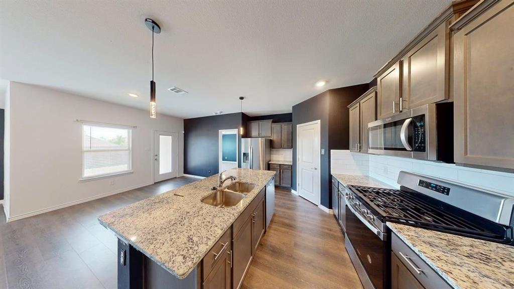 405 Rawhide Way Princeton, TX 75407 - Photo 4 of 22 a kitchen with stainless steel appliances granite countertop a stove oven and a refrigerator