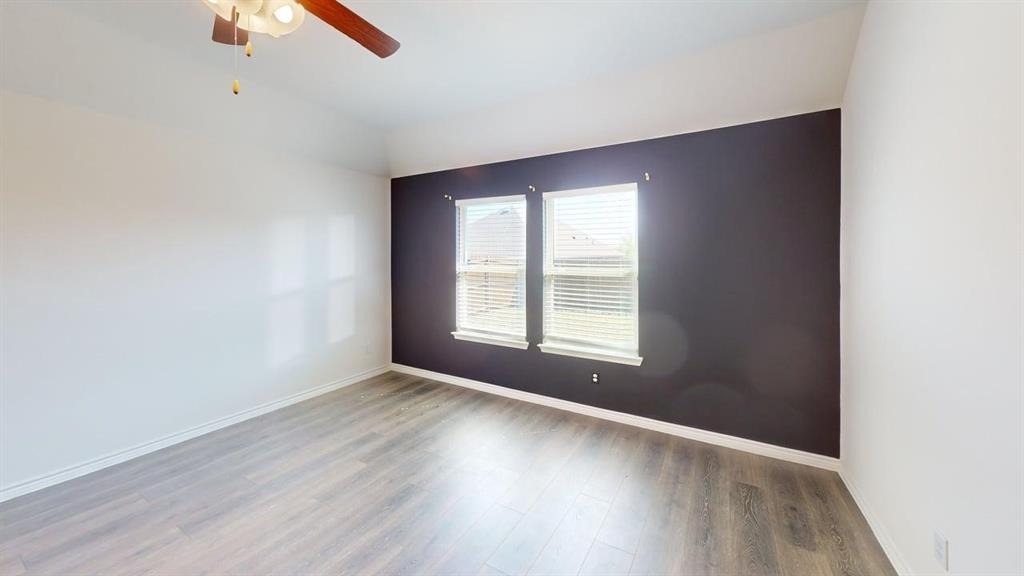 405 Rawhide Way Princeton, TX 75407 - Photo 9 of 22 an empty room with wooden floor fan and windows