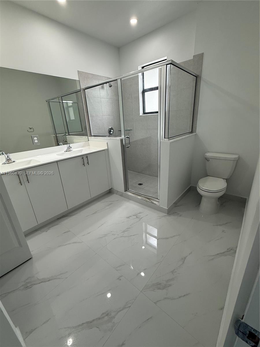 28519 Southwest 134th Court, Unit 28519 Homestead, FL 33033 - Photo 4 of 9 a bathroom with a toilet sink and mirror