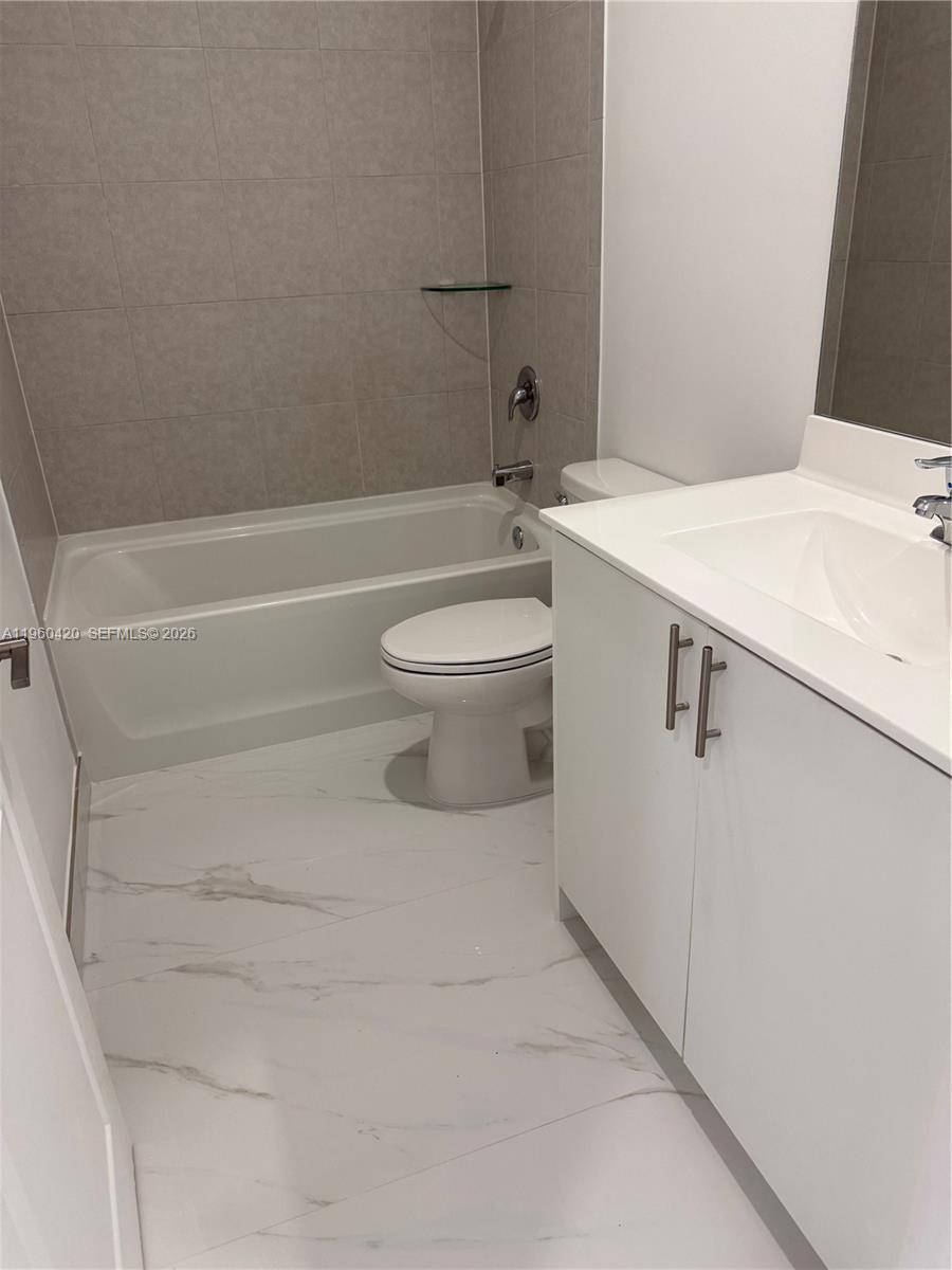 28519 Southwest 134th Court, Unit 28519 Homestead, FL 33033 - Photo 5 of 9 a bathroom with a sink a toilet and a bathtub
