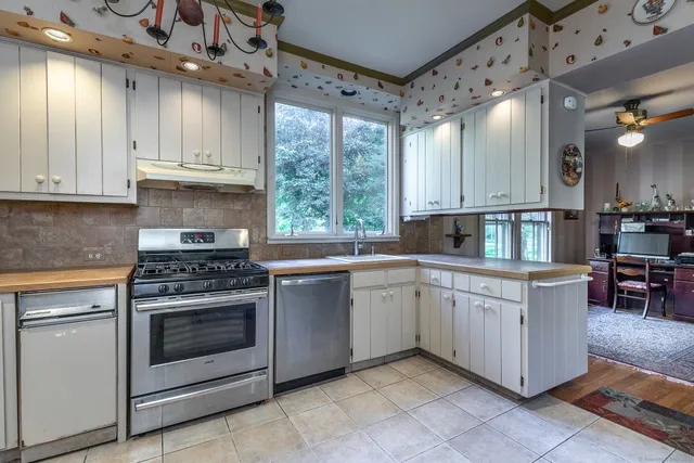a kitchen with granite countertop white cabinets and white appliances