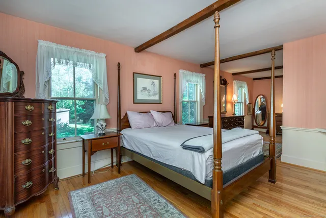 a bedroom with a bed a flat screen tv and a window