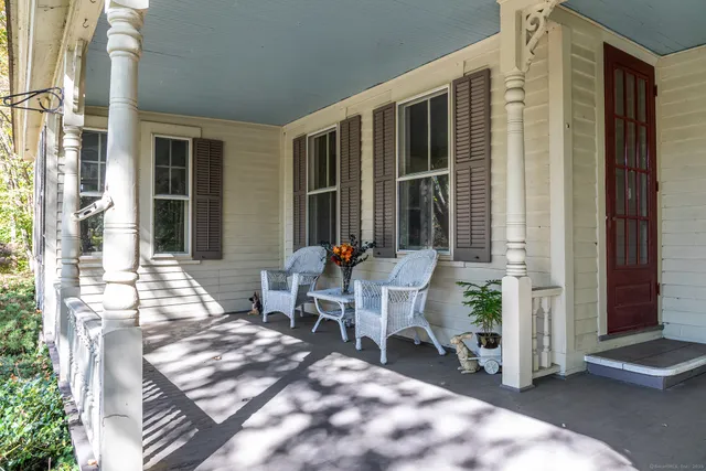 a balcony with chairs and glass door
