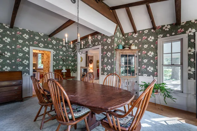 a dining room with furniture a chandelier and wooden floor