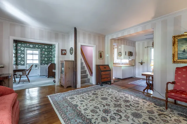 a living room with furniture a piano and a rug