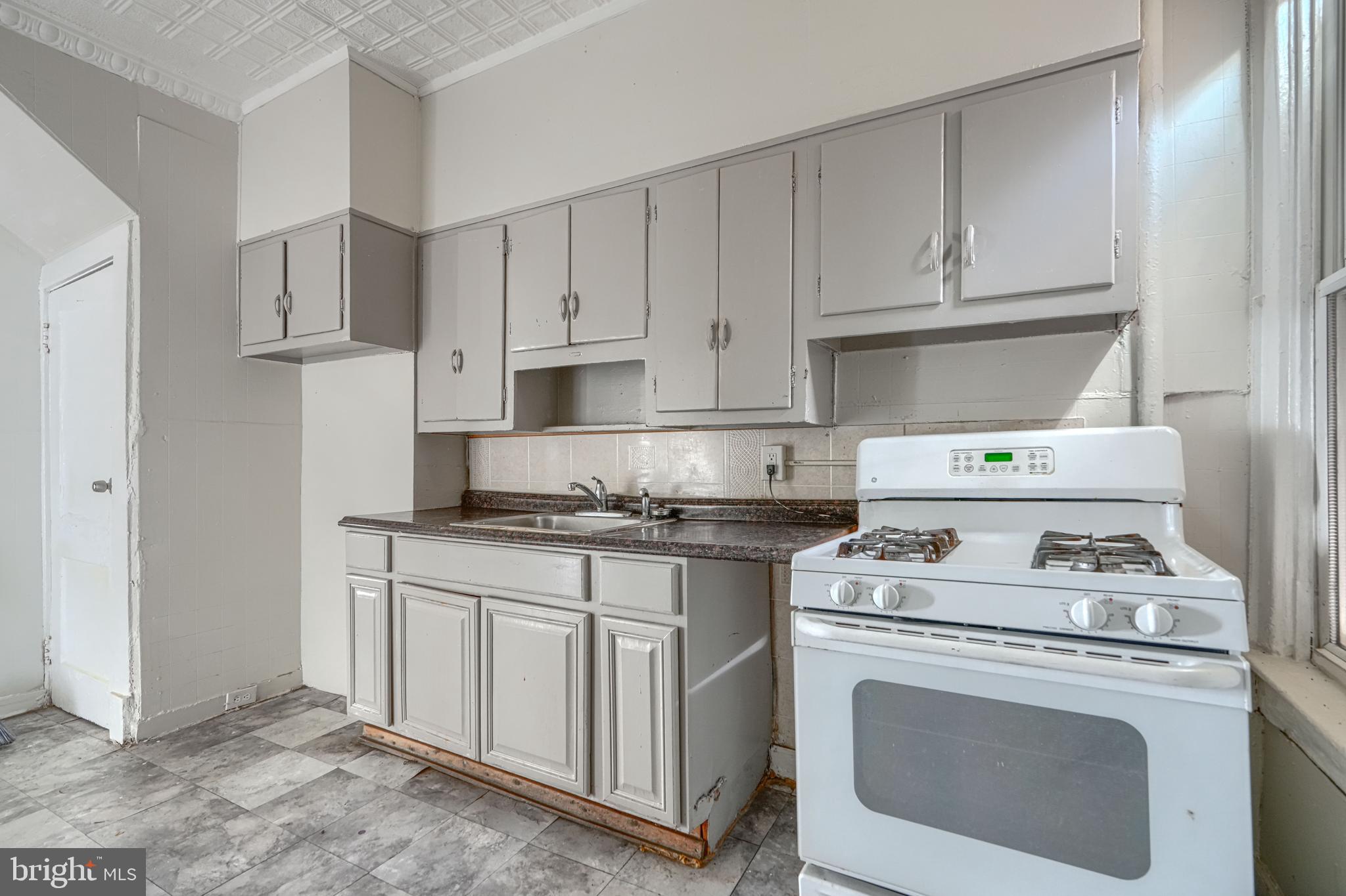 4806 Reisterstown Road Baltimore, MD 21215 - Photo 13 of 34 a kitchen with white cabinets and appliances
