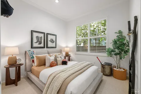 a bedroom with bed and a potted plant