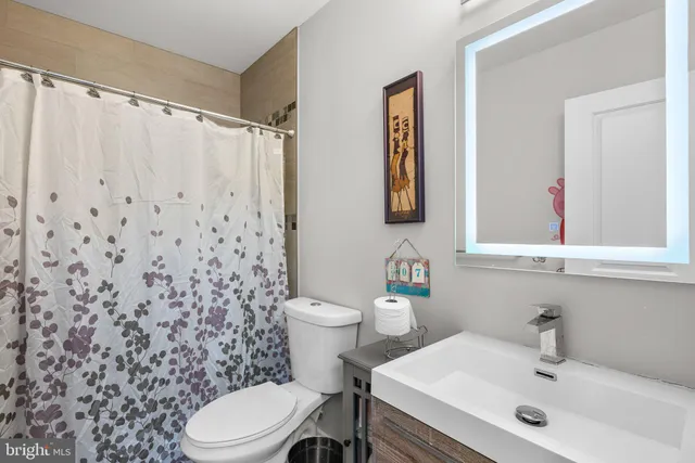 a bathroom with a sink a toilet and a mirror