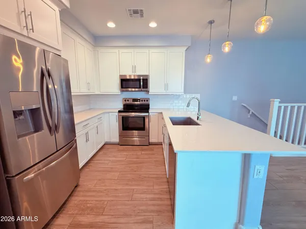 a kitchen with stainless steel appliances a refrigerator sink and microwave