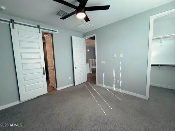 an empty room with windows and fan