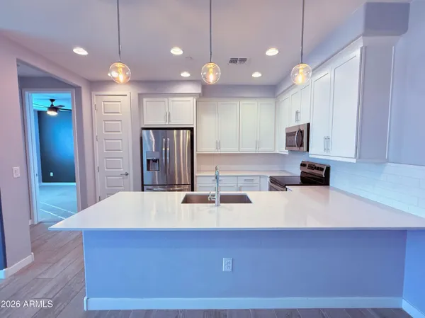 a kitchen with kitchen island a sink and a refrigerator