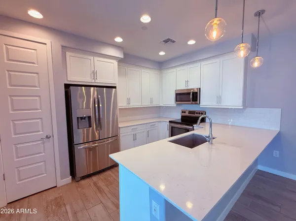 a kitchen with refrigerator cabinets and wooden floor