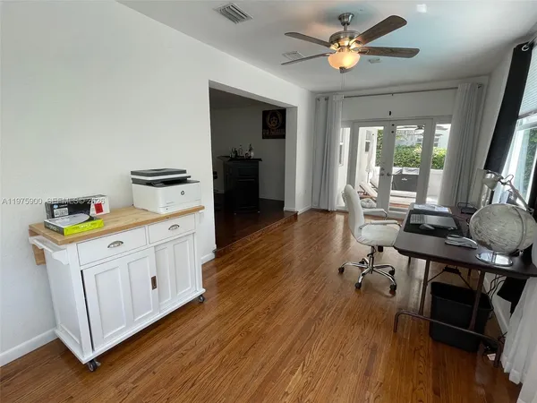 a kitchen that has a microwave a stove and wooden floor