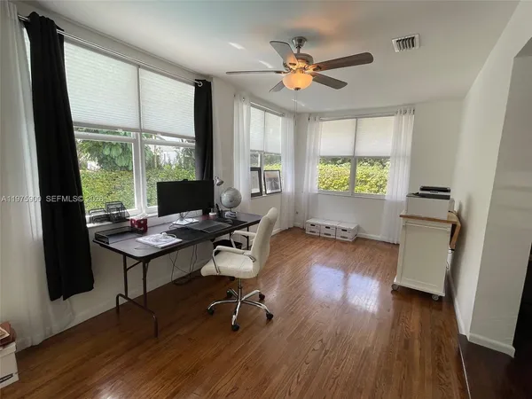 a view of a workspace with furniture and a window