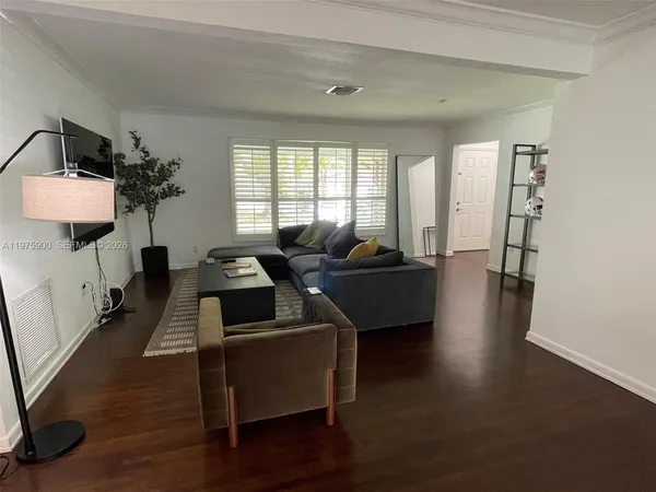 a living room with furniture and wooden floor