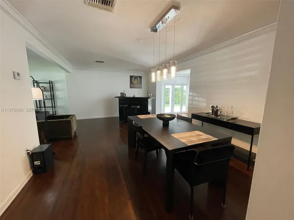 a kitchen with a table chairs refrigerator and cabinets