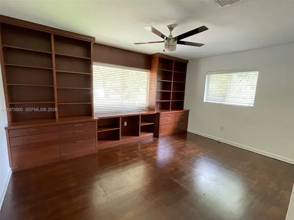 a view of a livingroom with wooden floor and windows