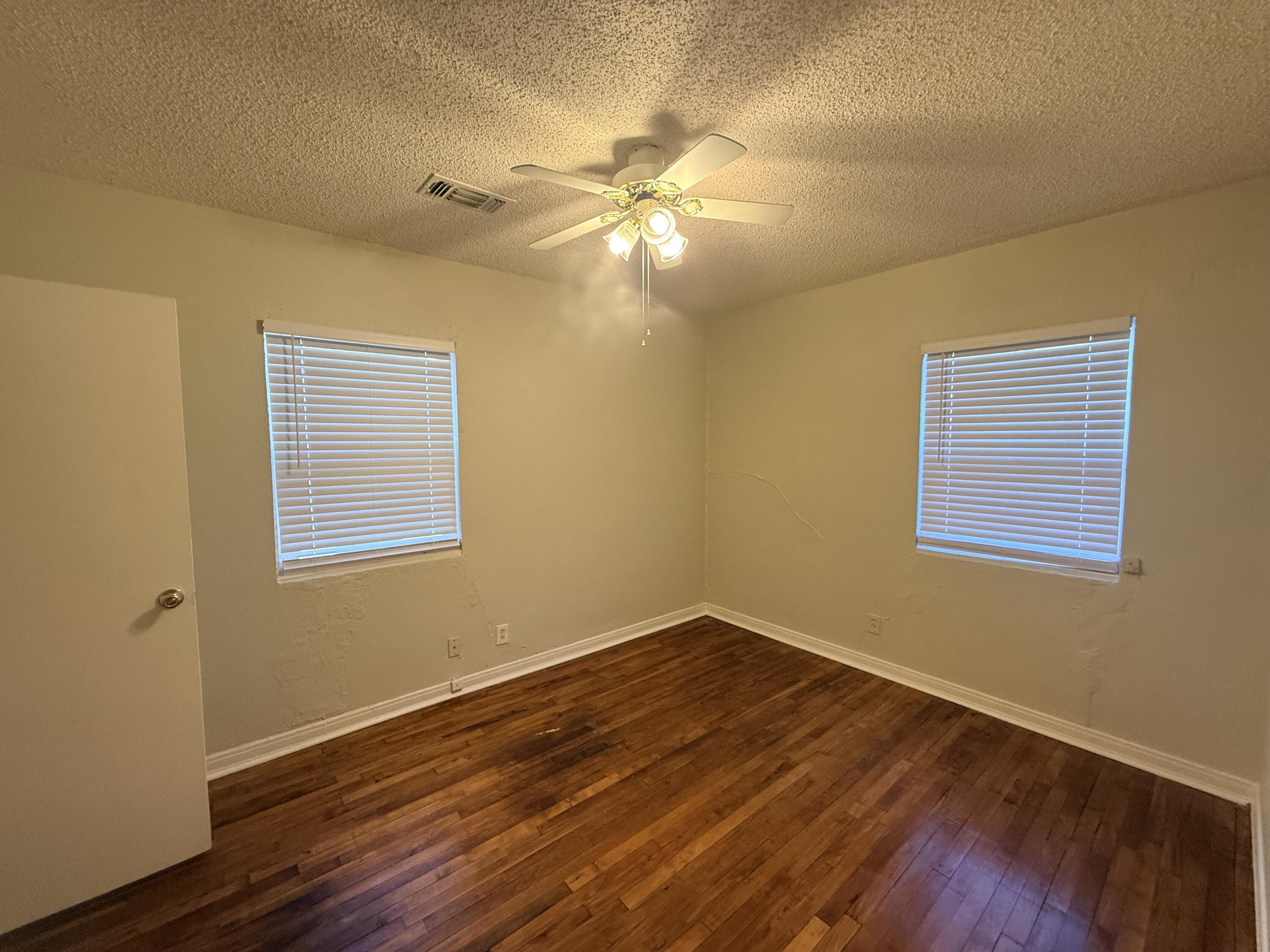 3418 25th Street Lubbock, TX 79410 - Photo 11 of 14 a view of an empty room with wooden floor and a window