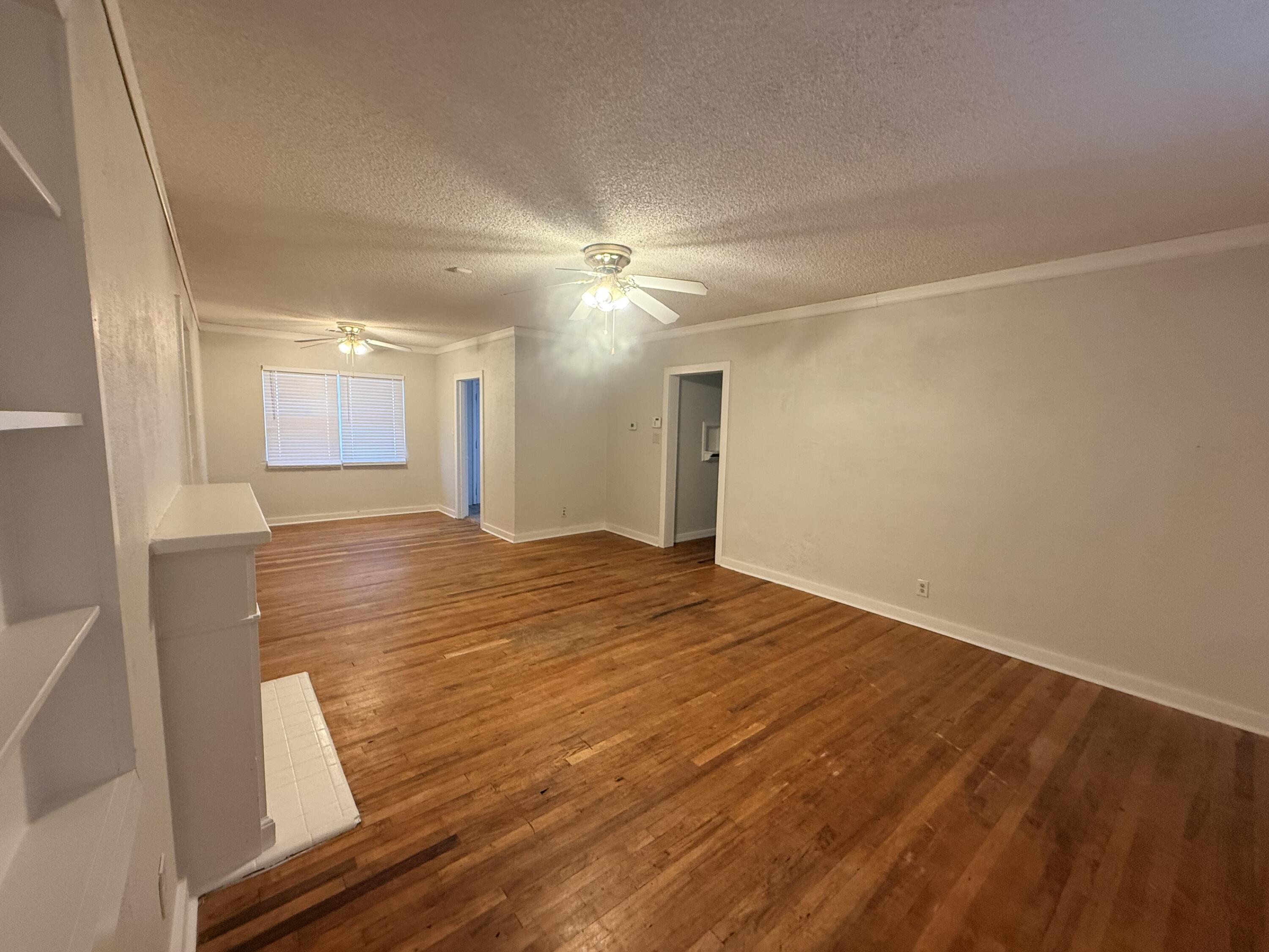 3418 25th Street Lubbock, TX 79410 - Photo 3 of 14 wooden floor in an empty room with a window