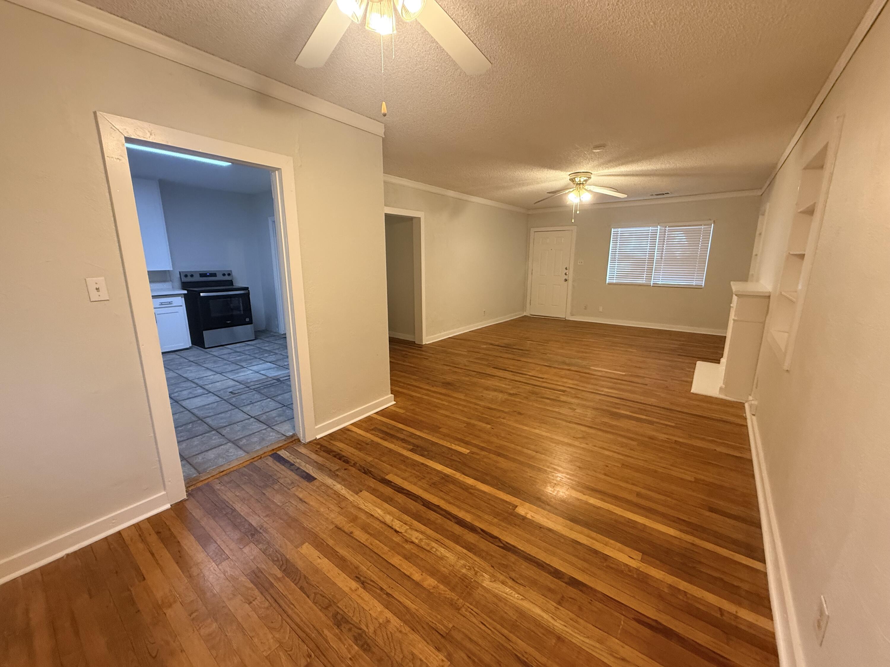 3418 25th Street Lubbock, TX 79410 - Photo 4 of 14 a view of a livingroom with wooden floor and a ceiling fan