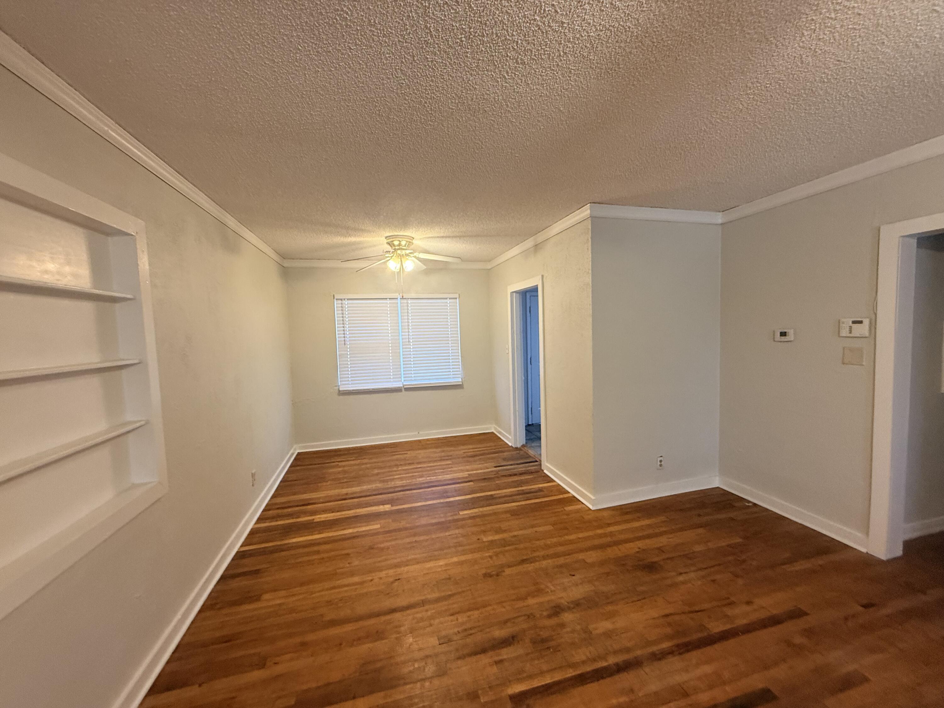 3418 25th Street Lubbock, TX 79410 - Photo 5 of 14 a view of an empty room with wooden floor and closet