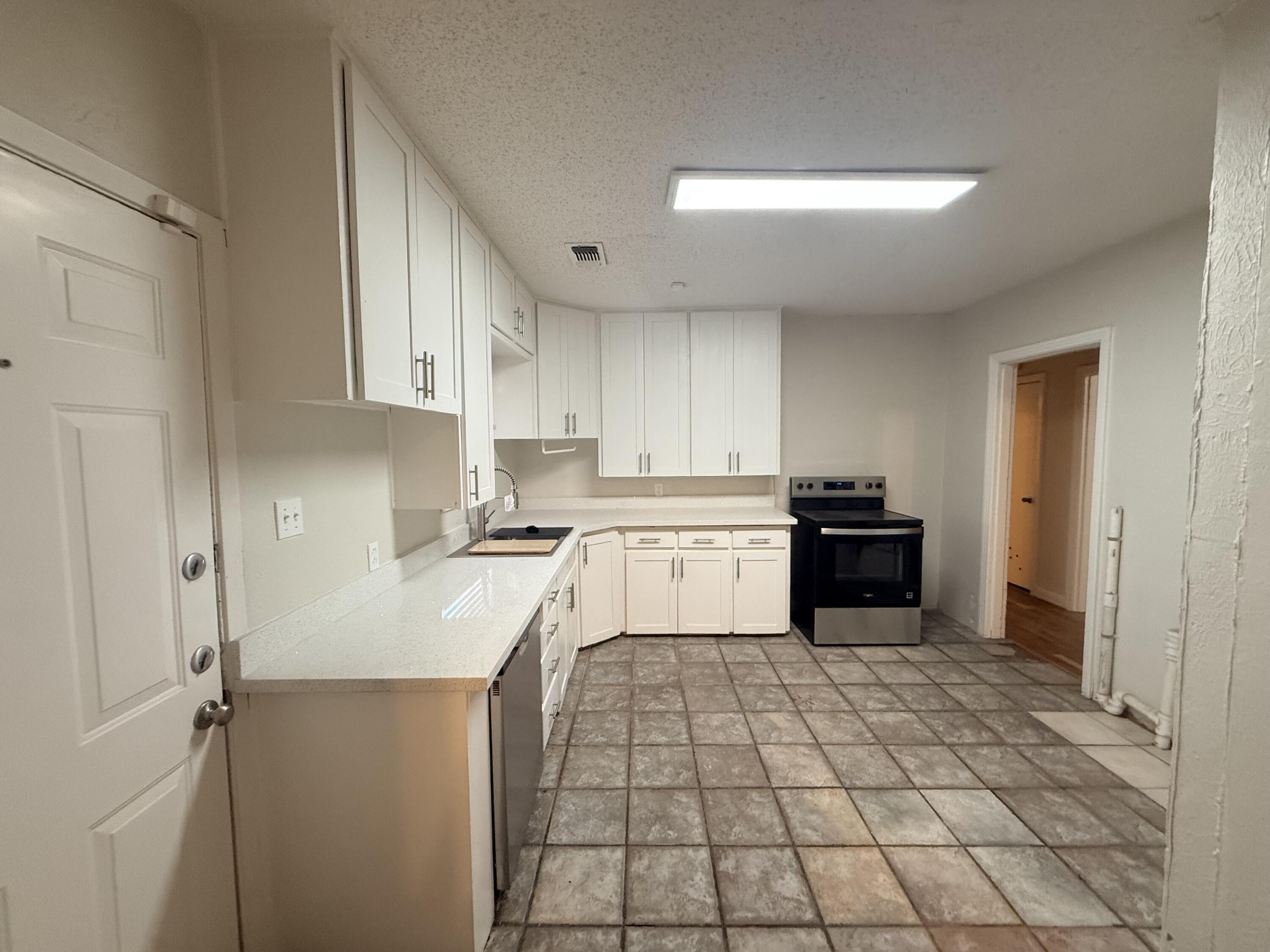 3418 25th Street Lubbock, TX 79410 - Photo 6 of 14 a kitchen with a sink a stove cabinets and counter space