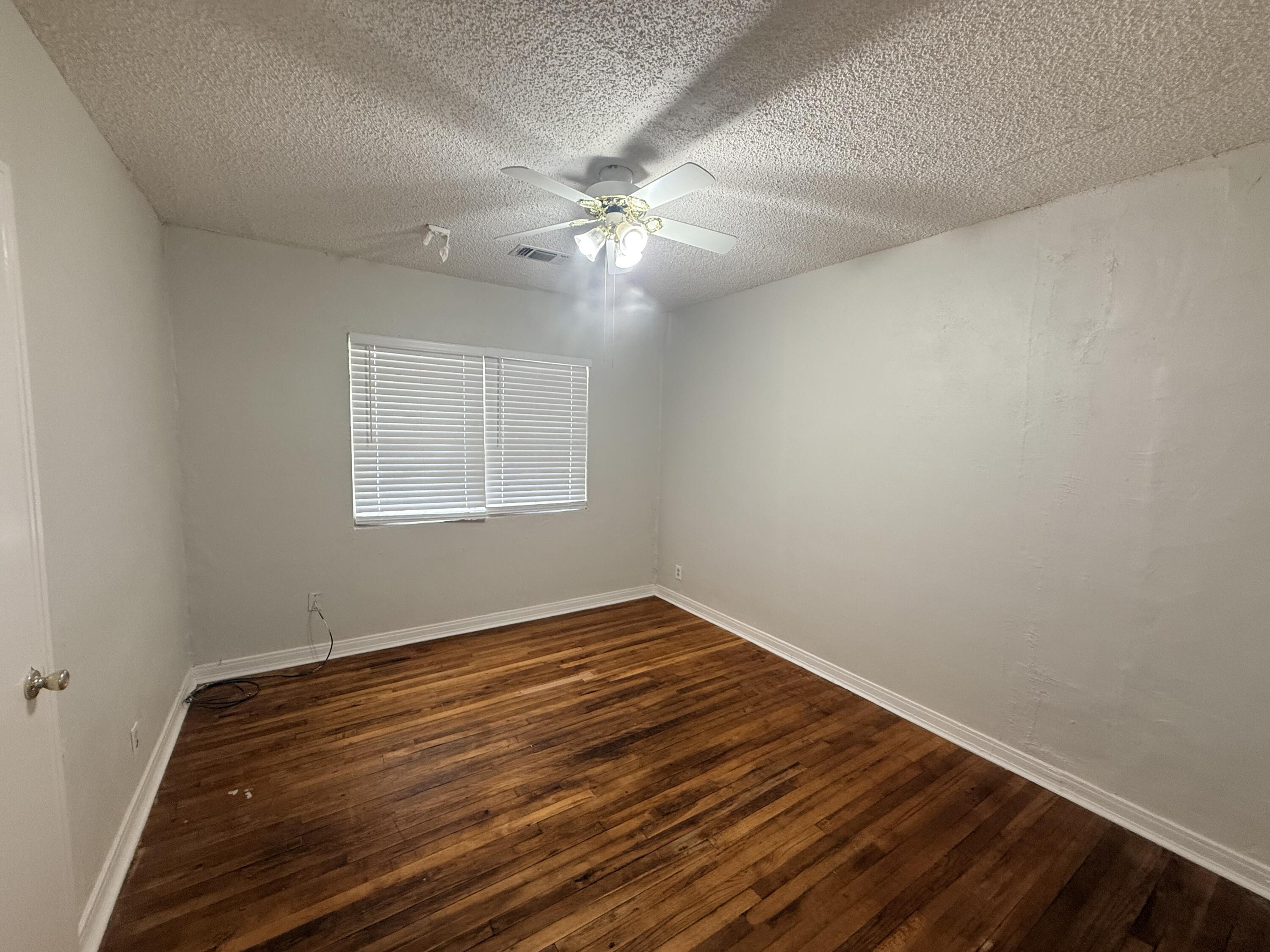 3418 25th Street Lubbock, TX 79410 - Photo 8 of 14 a view of an empty room with wooden floor and a window