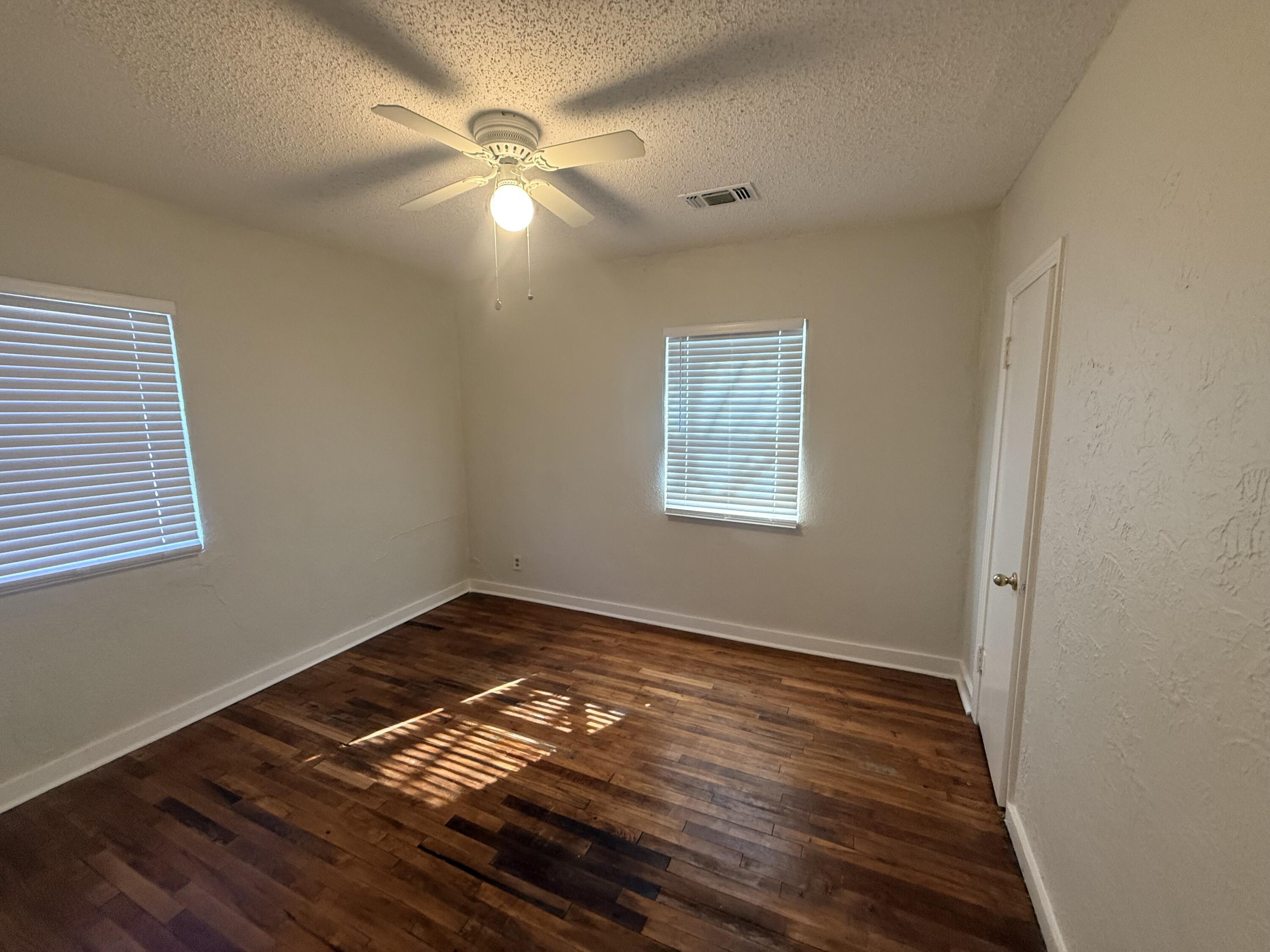 3418 25th Street Lubbock, TX 79410 - Photo 9 of 14 a view of an empty room with wooden floor and a window