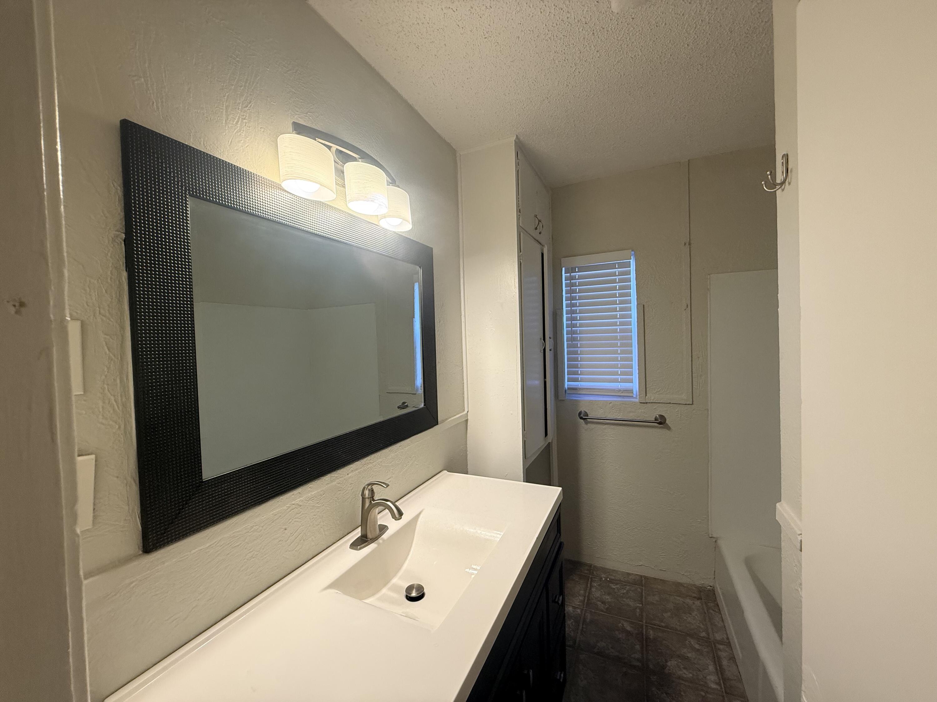 3418 25th Street Lubbock, TX 79410 - Photo 10 of 14 a bathroom with a sink and a mirror