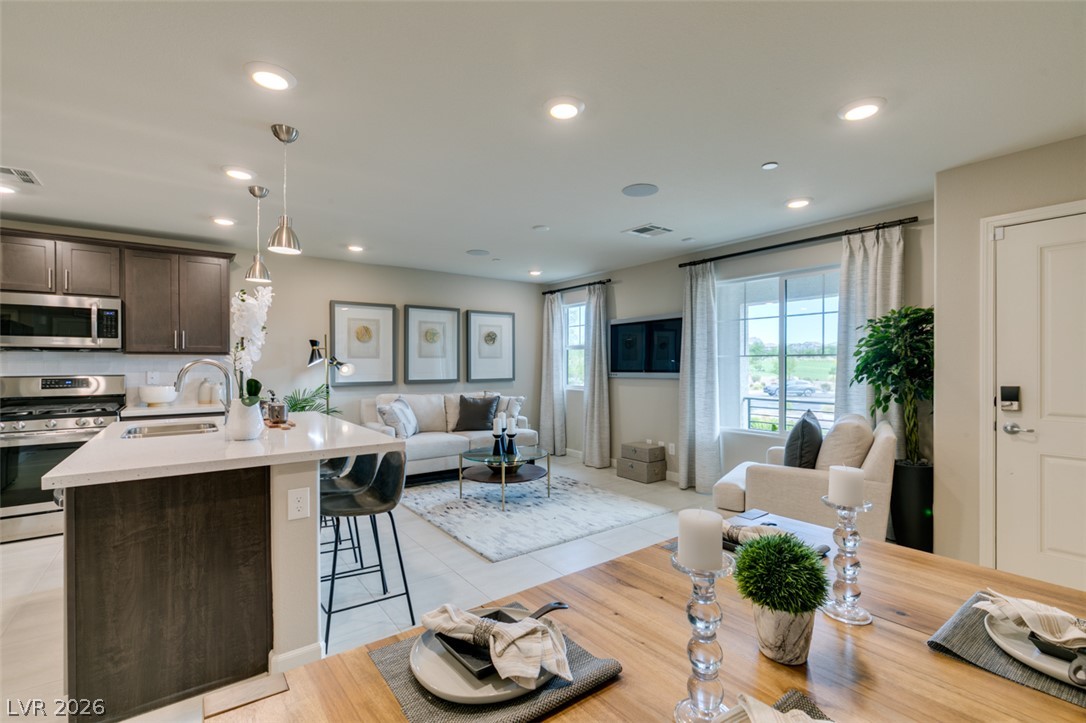 653 Pickled Pepper Place Henderson, NV 89011 - Photo 5 of 35 An inviting open-concept living area seamlessly connects the kitchen, dining, and family spaces.