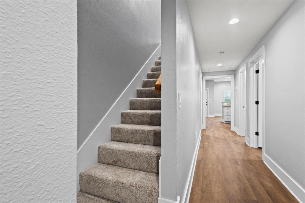 724 West Gandy Street Denison, TX 75020 - Photo 23 of 31 a view of a hallway with wooden floor and staircase