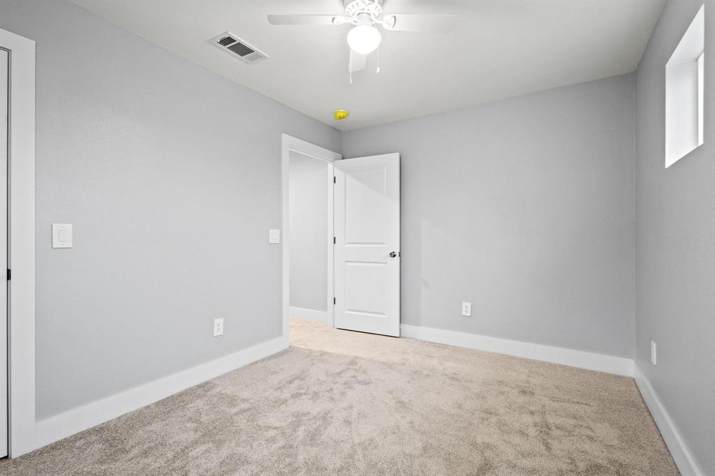 724 West Gandy Street Denison, TX 75020 - Photo 25 of 31 an empty room with a chandelier fan and windows