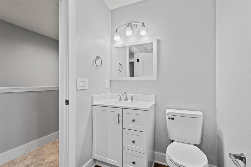 724 West Gandy Street Denison, TX 75020 - Photo 26 of 31 a bathroom with a toilet a sink and mirror