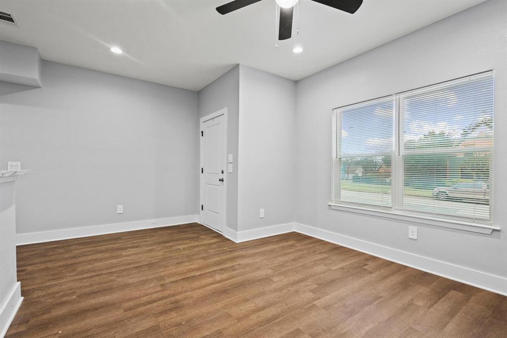 724 West Gandy Street Denison, TX 75020 - Photo 8 of 31 an empty room with wooden floor and windows