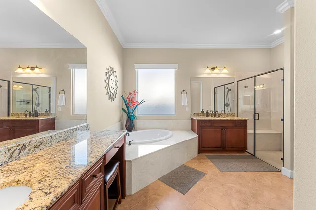 a en suite bathroom with a granite countertop sink and a mirror