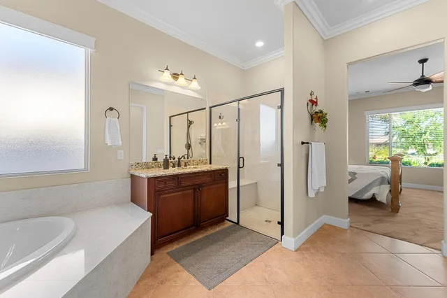 a view of a hallway with wooden floor and a bathroom