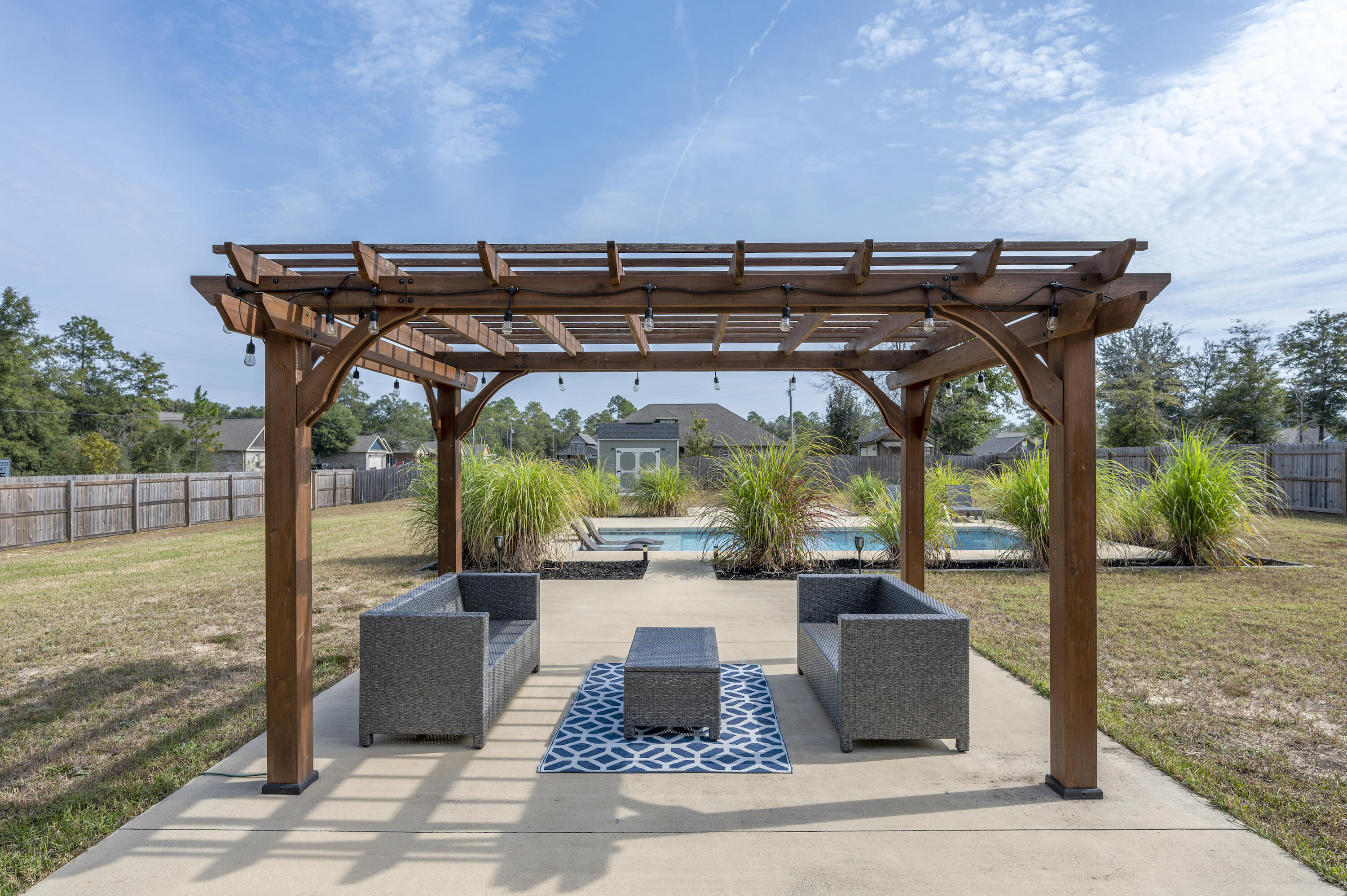 3960 Painter Branch Road Crestview, FL 32539 - Photo 36 of 46 a view of a patio with table and chairs under an umbrella with a barbeque