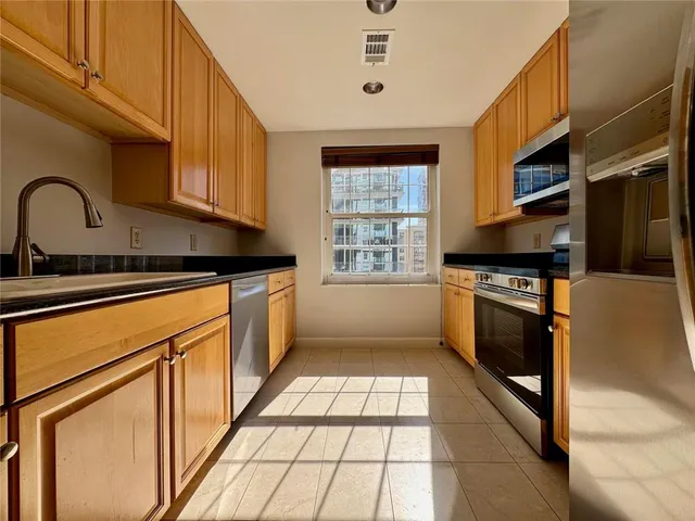 a view of a patio with table and chairs potted plants and large tree