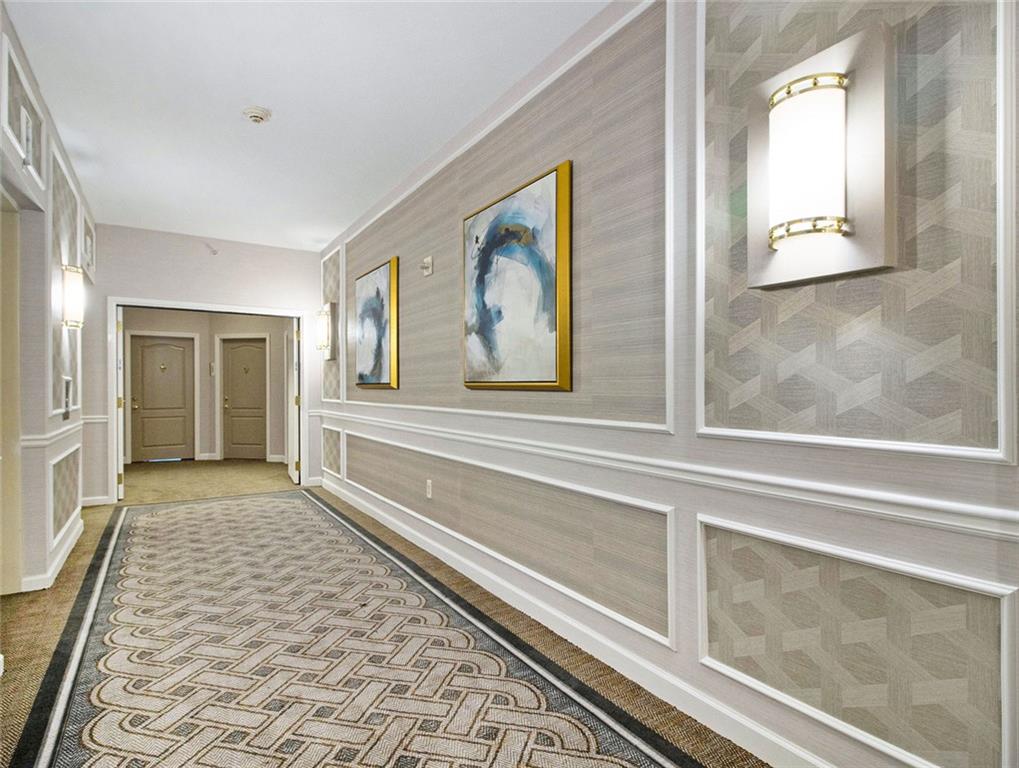 195 14th Street Northeast, Unit 1501 Atlanta, GA 30309 - Photo 6 of 47 a view of a hallway with wooden floor and a fireplace