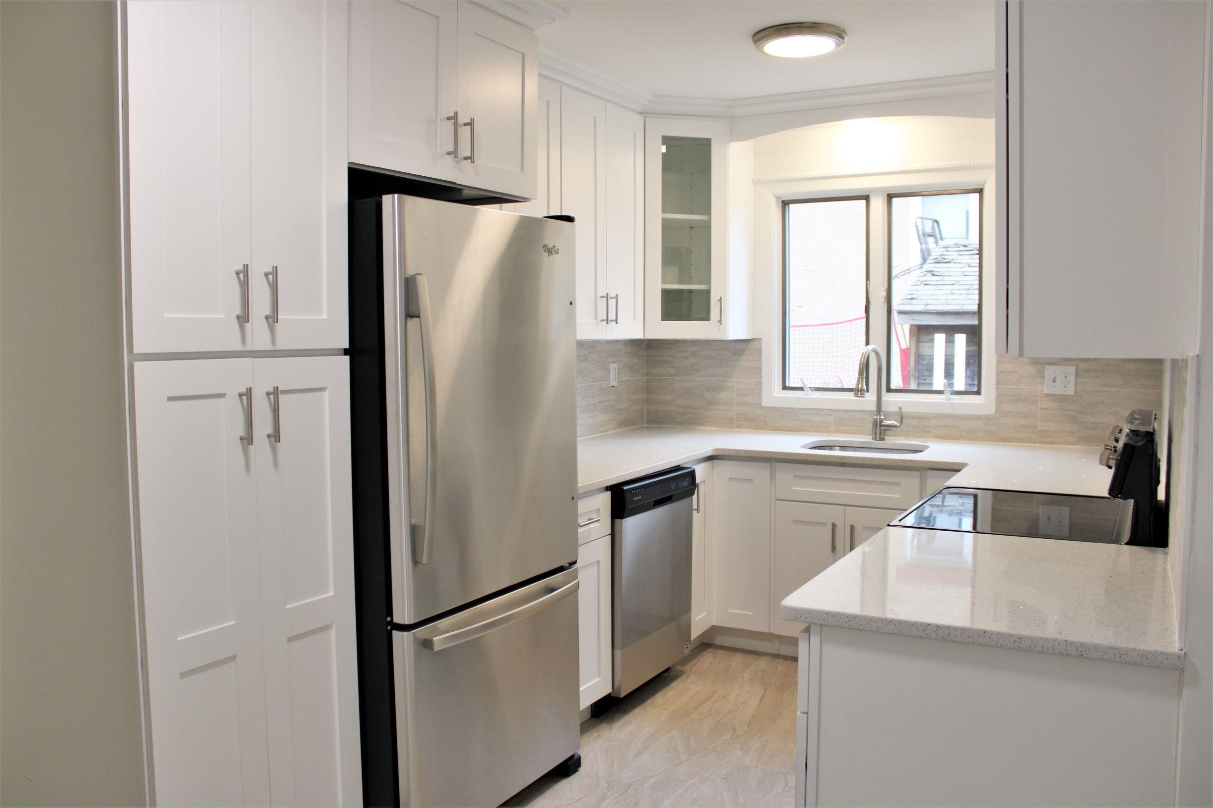 a kitchen with a refrigerator a sink and cabinets
